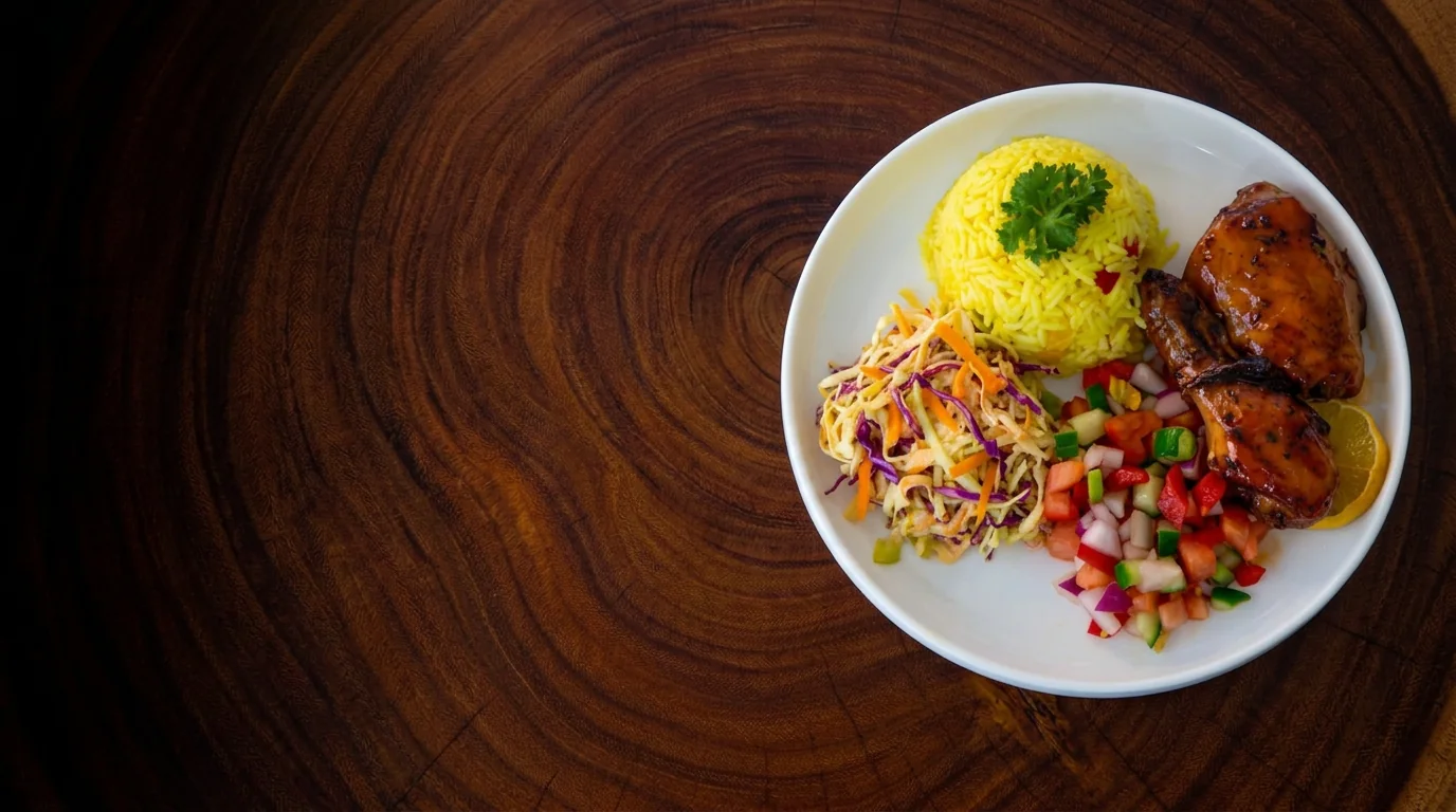 Mama’s grilled chicken, yellow rice, coleslaw and fresh salsa on a wooden table